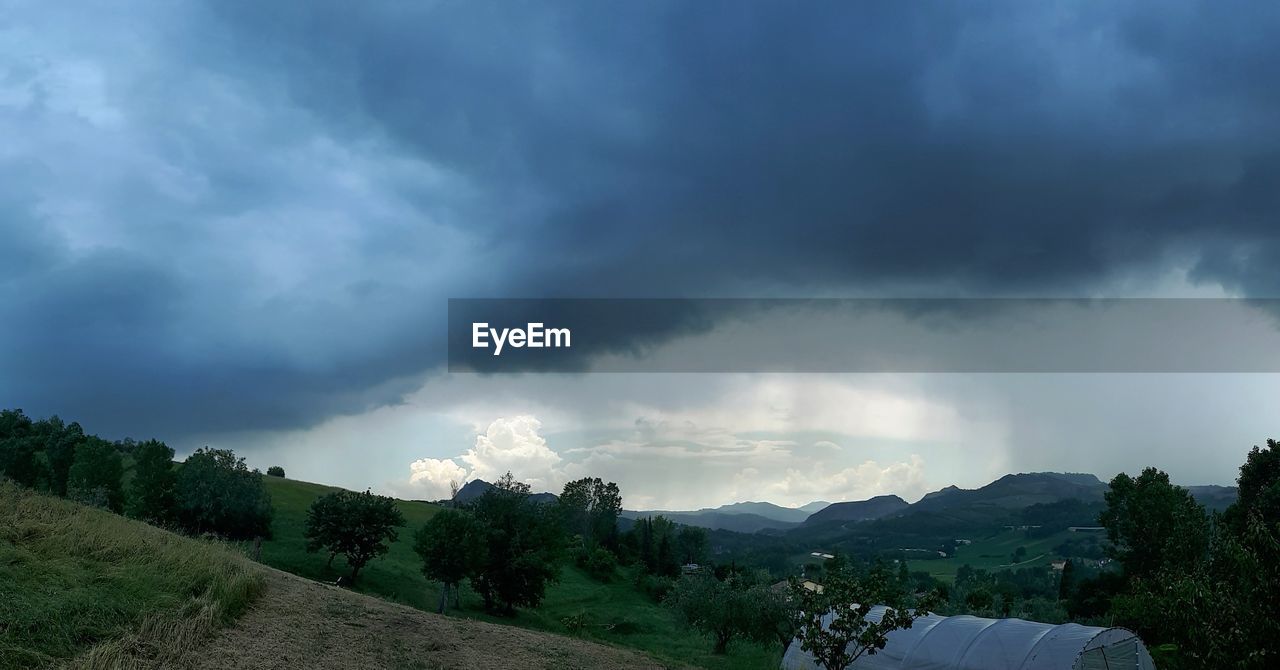 SCENIC VIEW OF STORM CLOUDS OVER LANDSCAPE