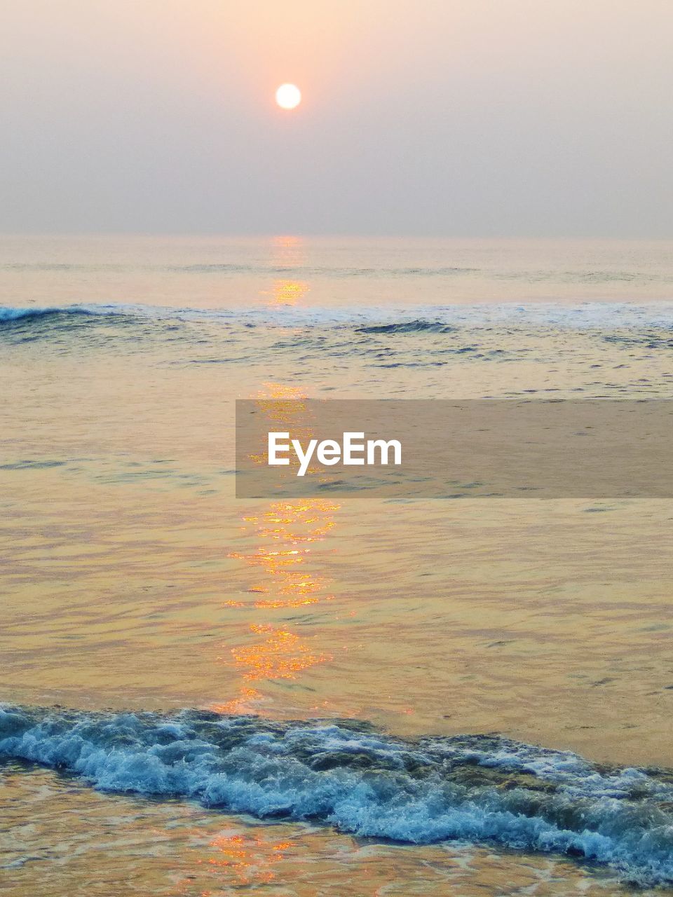 SCENIC VIEW OF BEACH AT SUNSET