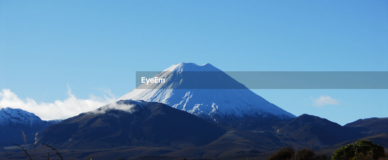 Scenic view of snowcapped mountain against blue sky