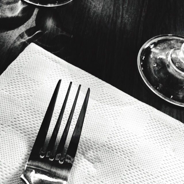 Close-up of fork and tissue paper on restaurant table