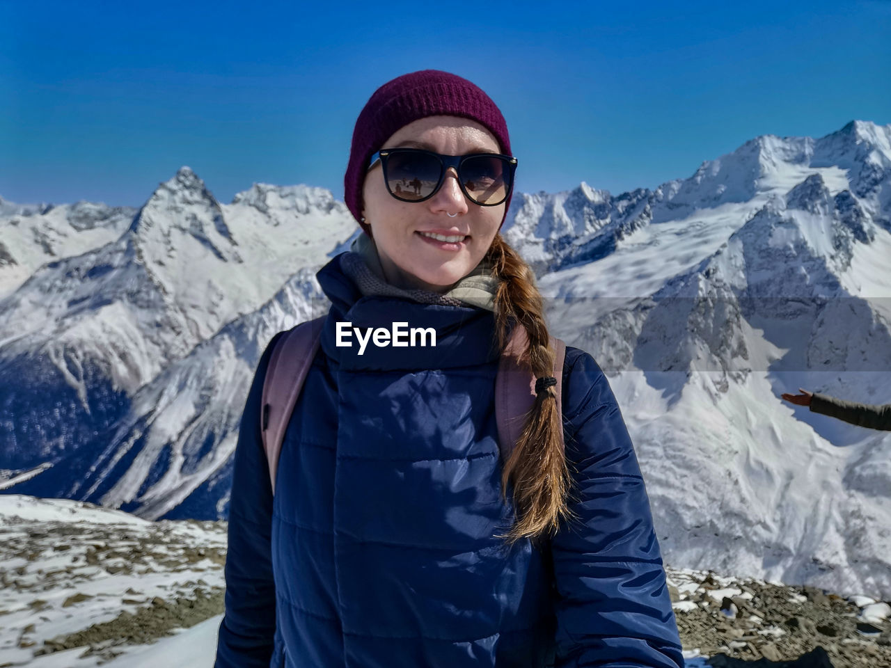 Portrait of woman standing on snowcapped mountains during winter