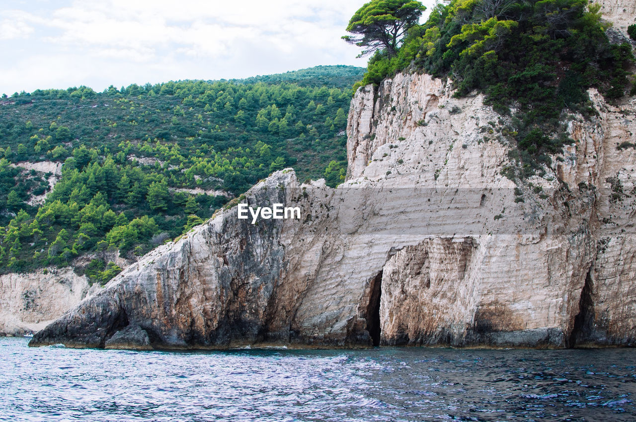 Scenic view of rock formation by sea against sky