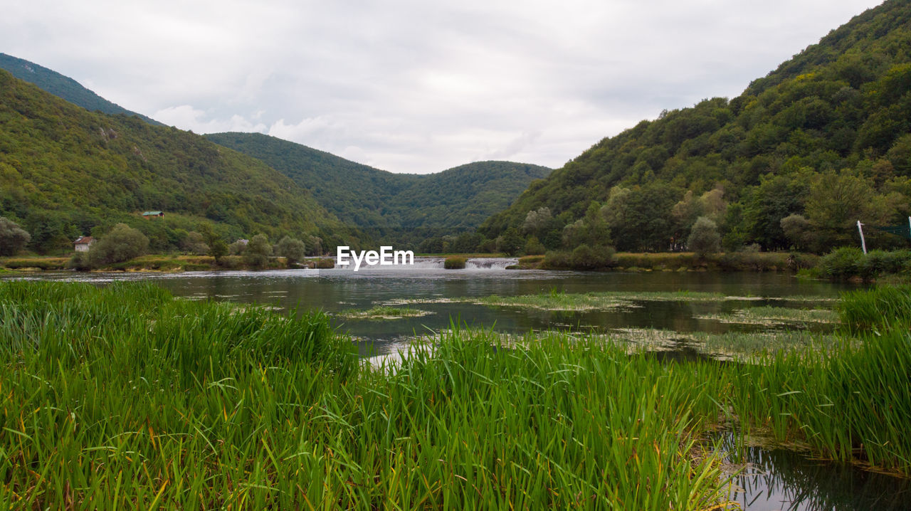 SCENIC VIEW OF LAKE AND MOUNTAIN AGAINST SKY