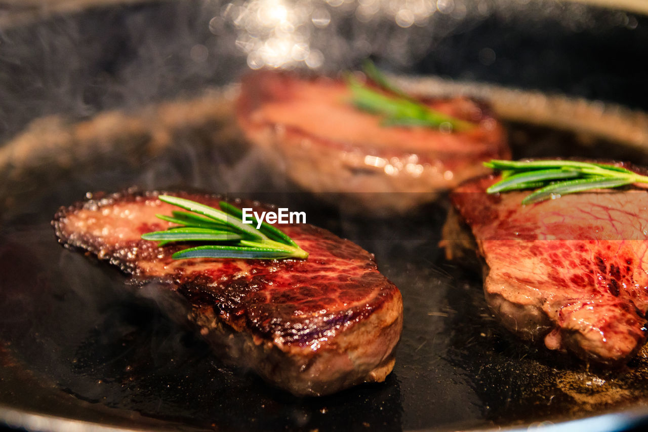 CLOSE-UP OF MEAT IN COOKING PAN