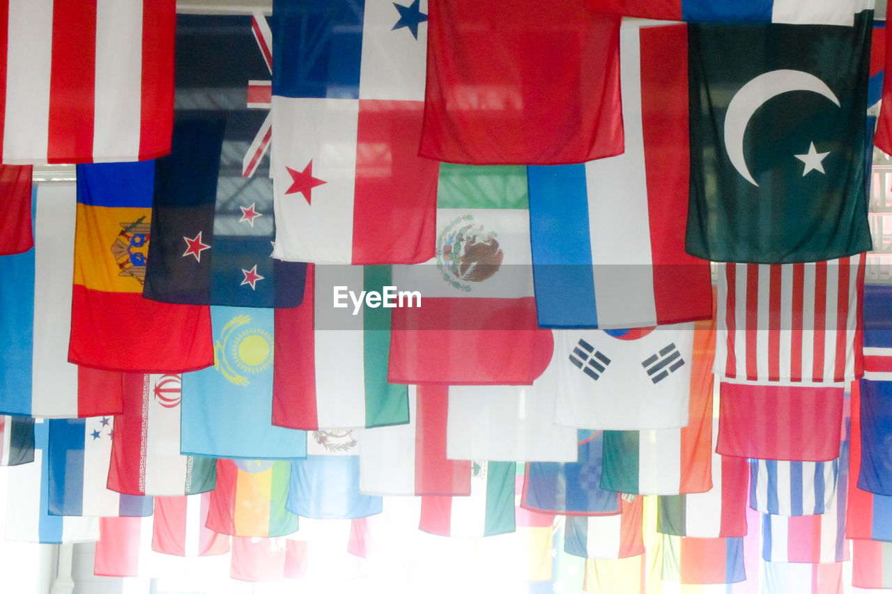 CLOSE-UP OF MULTI COLORED FLAGS HANGING ON PAPER