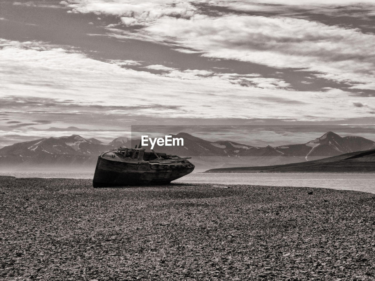 Whaler boat on sea shore against sky, svalbard coast