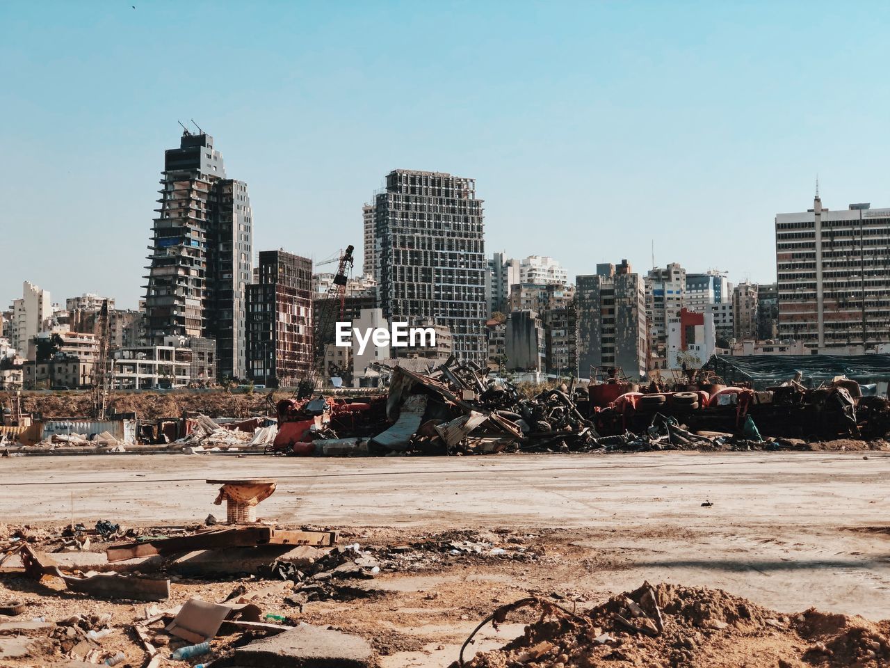 Destroyed cars from the beorut explosion with destroyed city skyline against clear sky