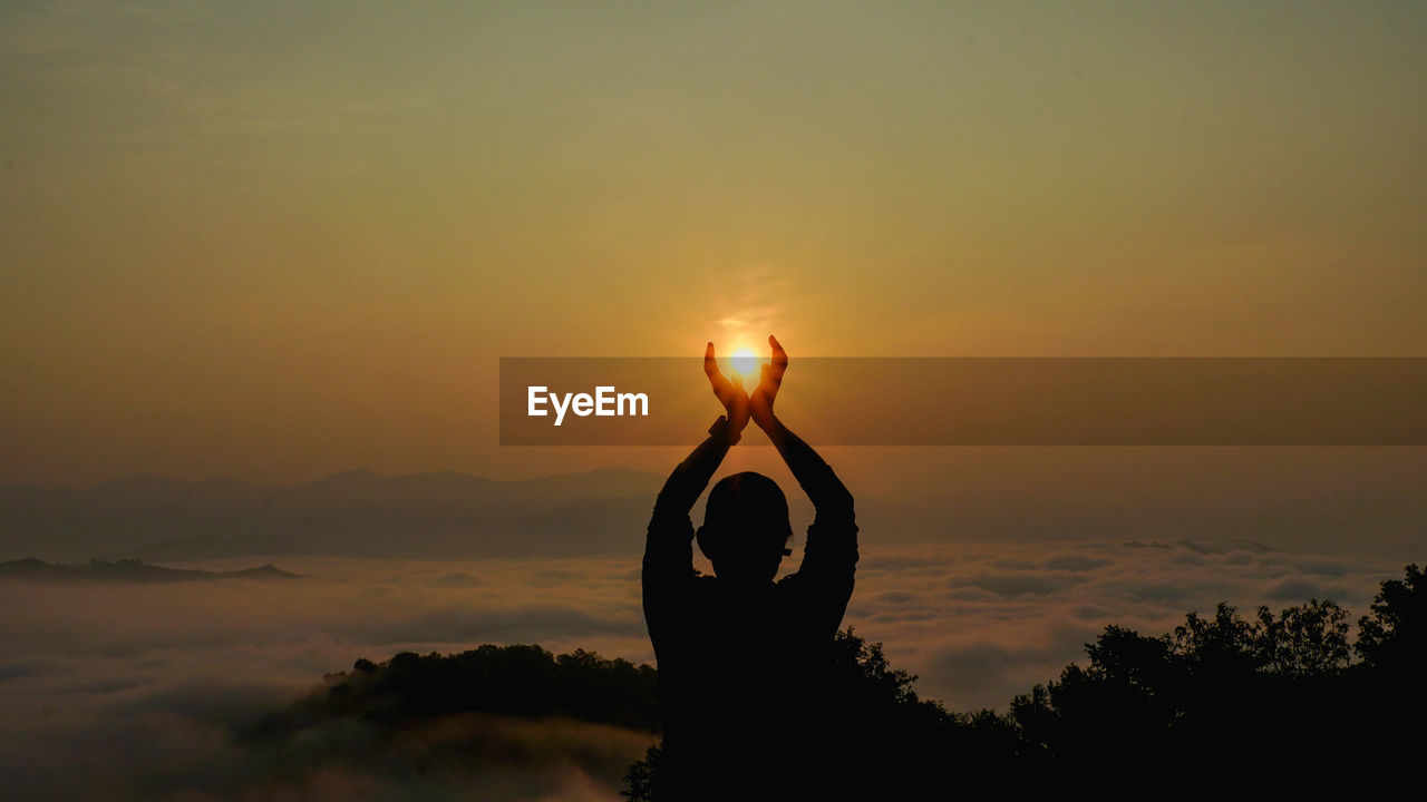 Silhouette person with heart shape against sky during sunset