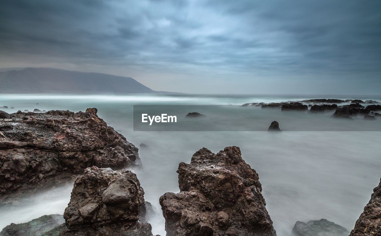 View of rocks in the sea near playa brava