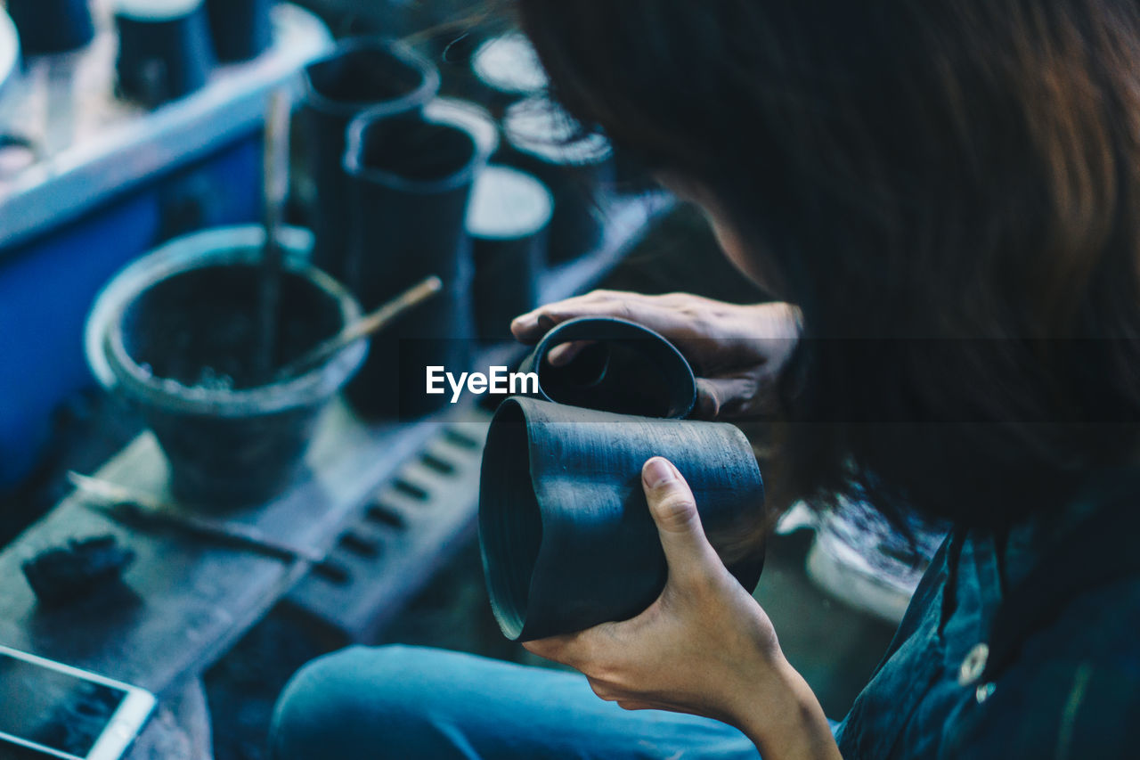 CLOSE-UP OF WOMAN HAND HOLDING COFFEE CUP WITH TEXT