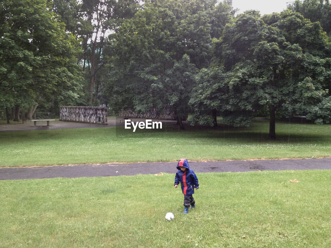 Boy playing with toy at park during rainy season