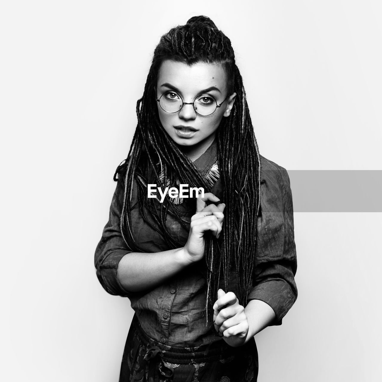 portrait of smiling young woman standing against white background