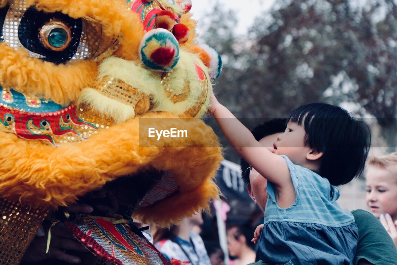 CLOSE-UP OF BABY BOY HOLDING TOY IN PARK