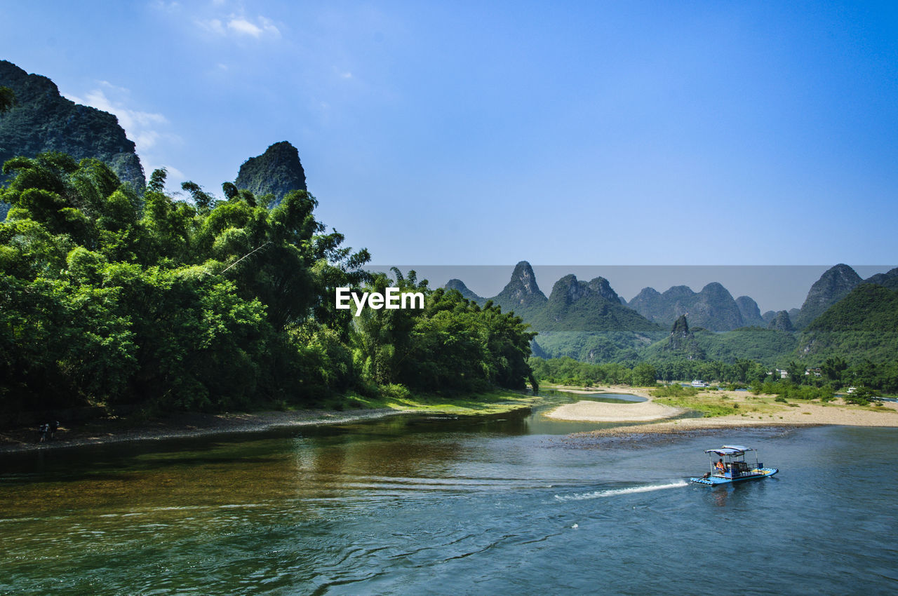 SCENIC VIEW OF RIVER AND TREE MOUNTAINS AGAINST SKY