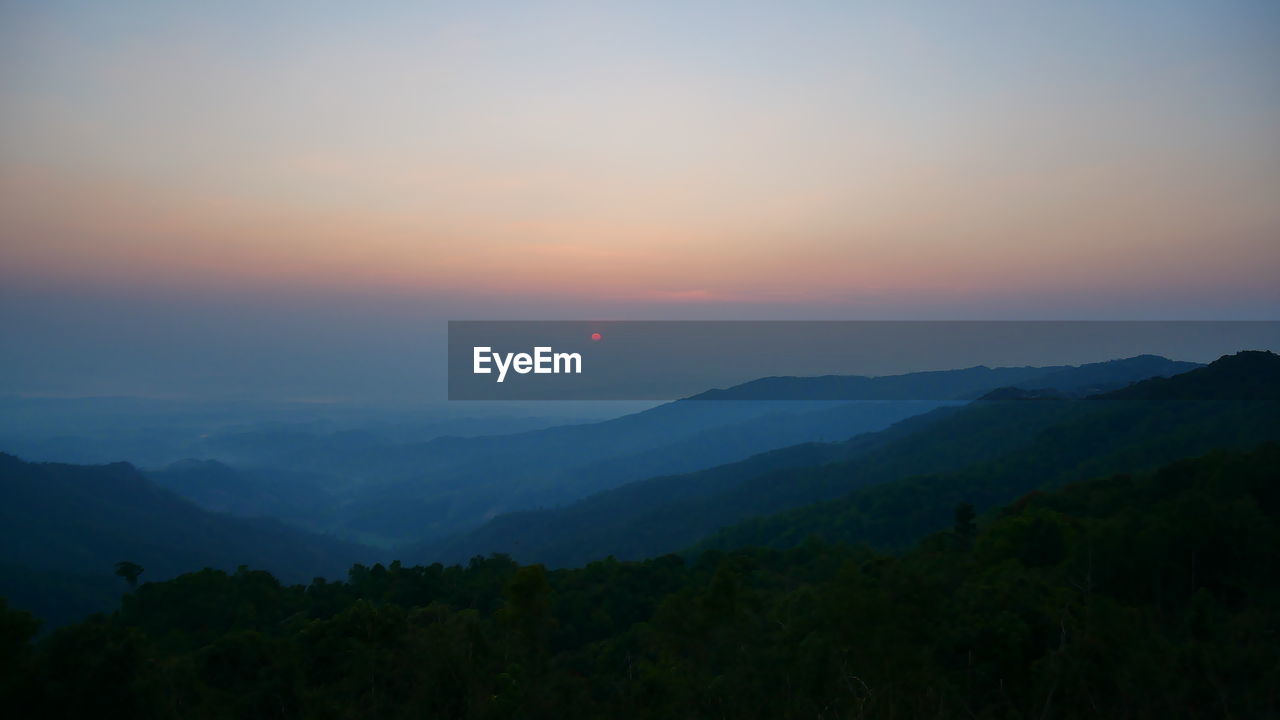 SCENIC VIEW OF MOUNTAINS AGAINST SKY AT SUNSET