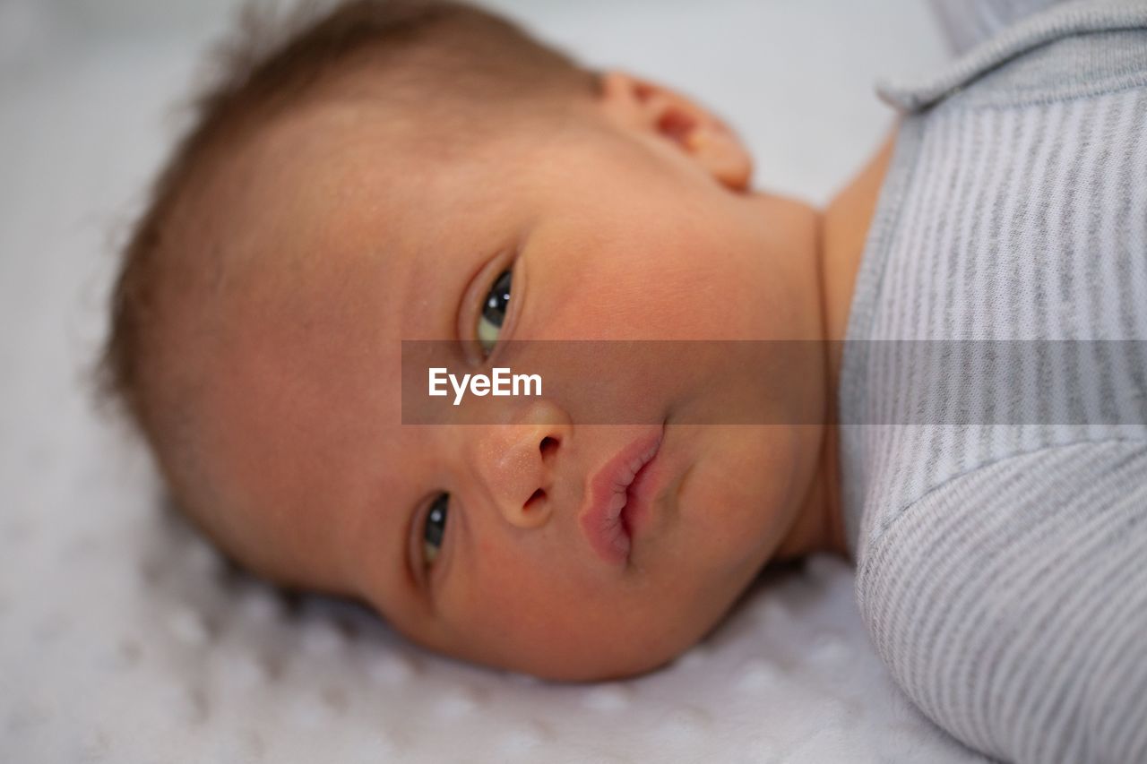 Portrait of cute baby lying on bed