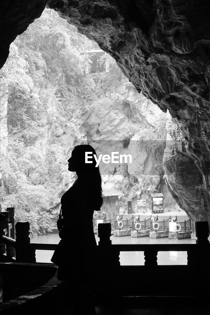 SIDE VIEW OF SILHOUETTE WOMAN STANDING IN CAVE