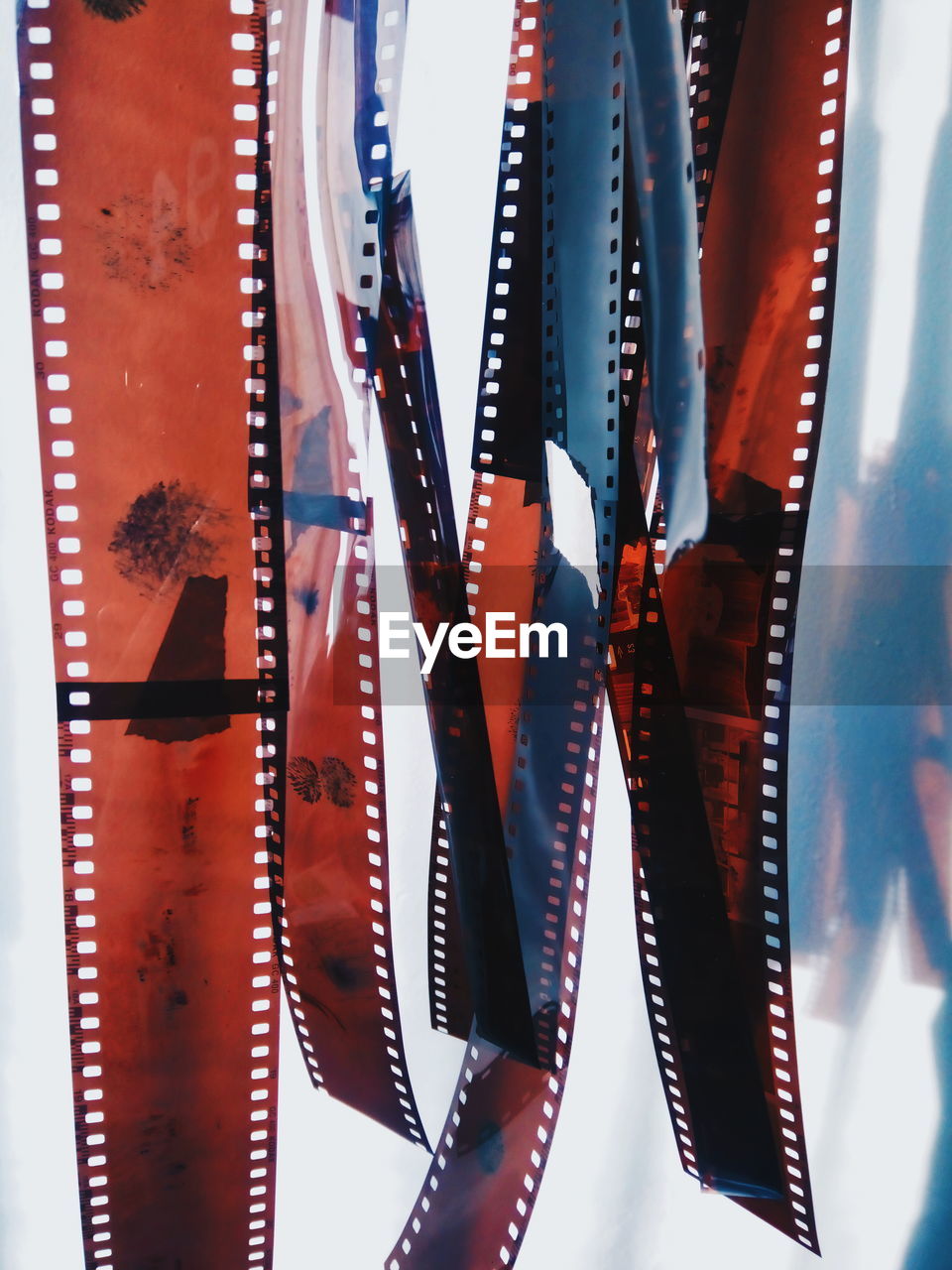 Close-up of film reels hanging against white background