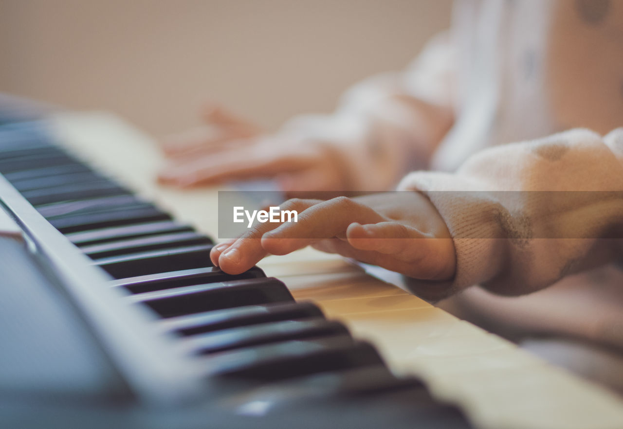 A little girl plays the electric piano.