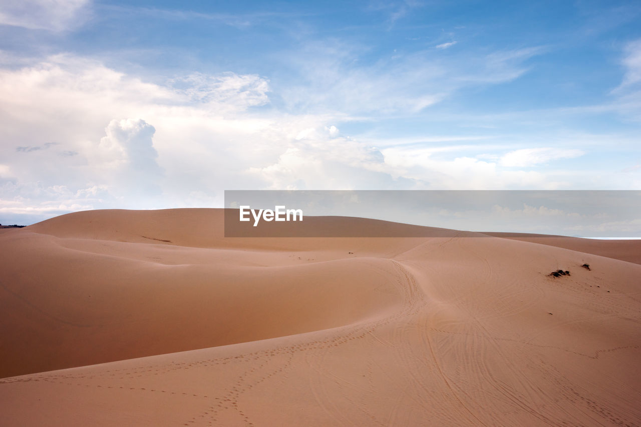 Sand dunes in desert against sky