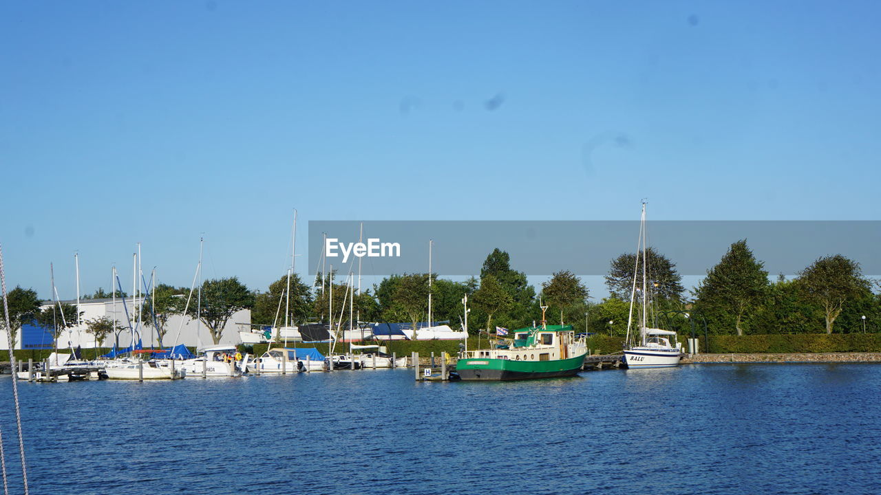 BOATS IN MARINA AGAINST BLUE SKY