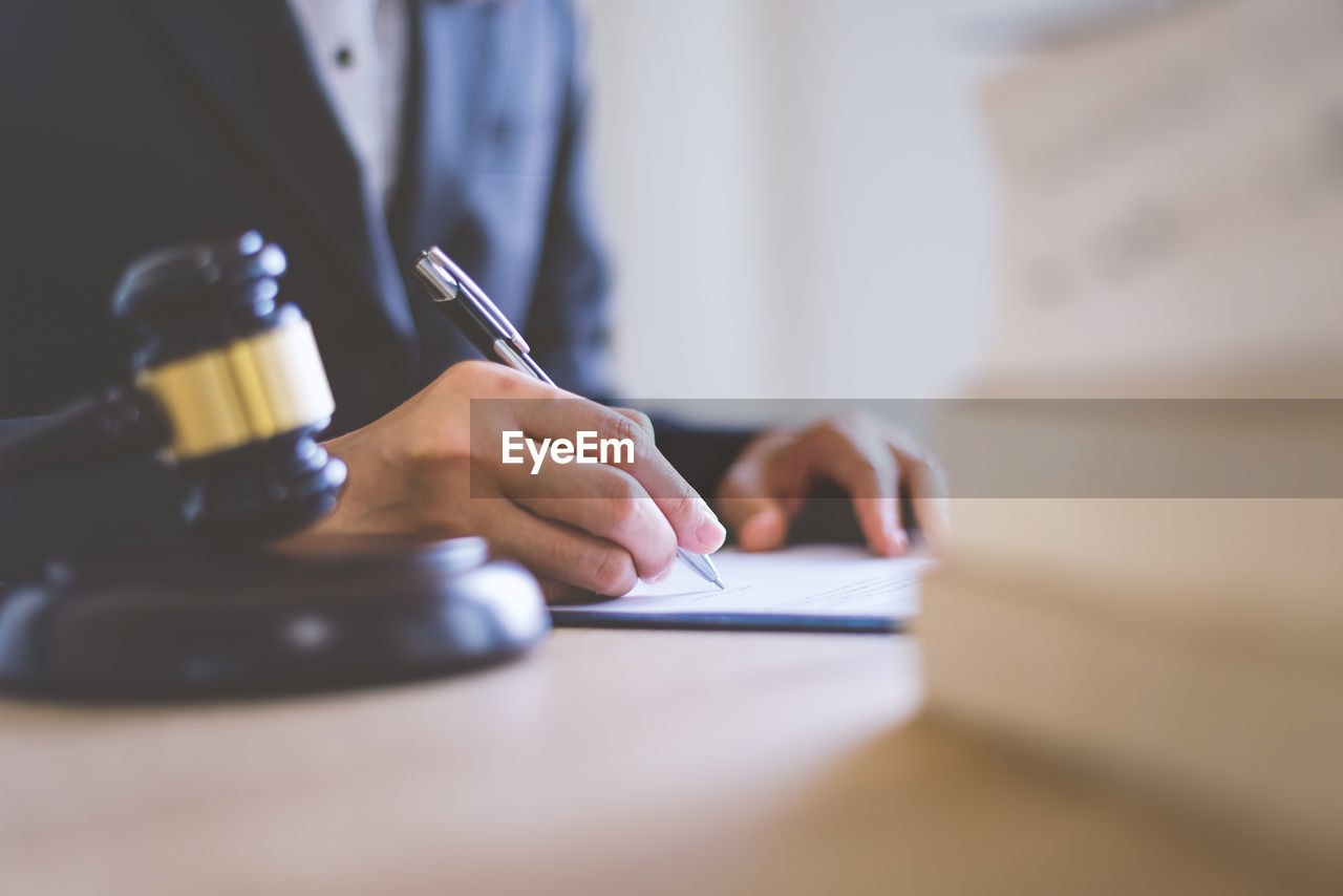 Midsection of lawyer writing on paper