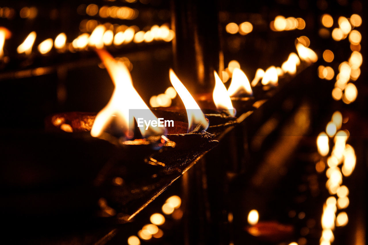 Close-up of lit oil lamps