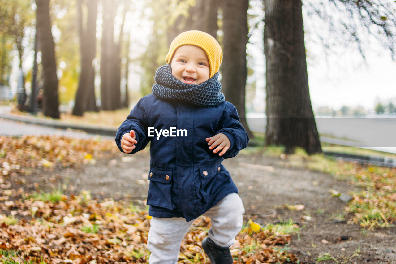 Portrait of cute baby boy standing in park