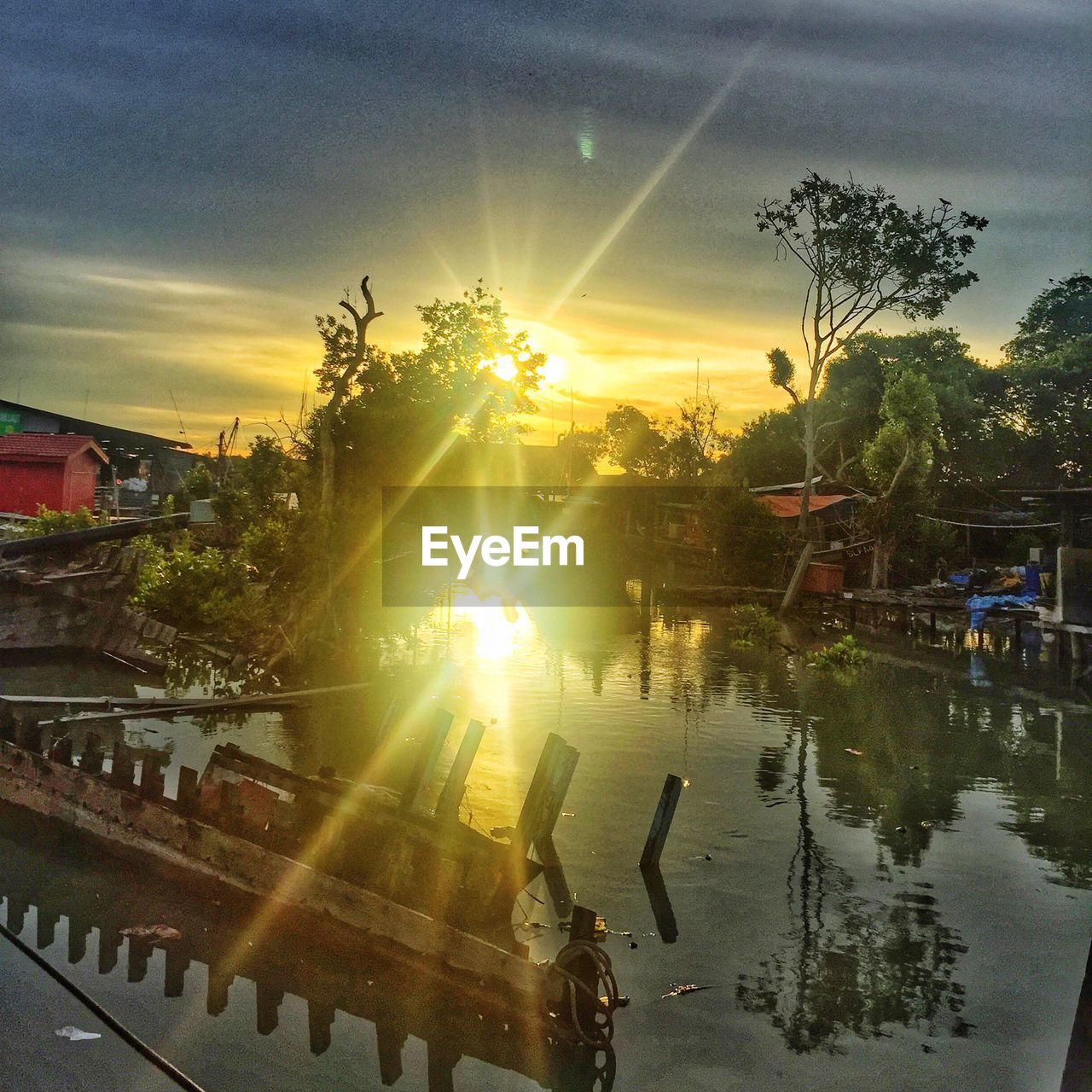 SUN SHINING OVER SWIMMING POOL AGAINST SKY