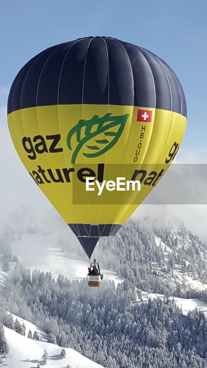 VIEW OF HOT AIR BALLOON FLYING OVER SNOW