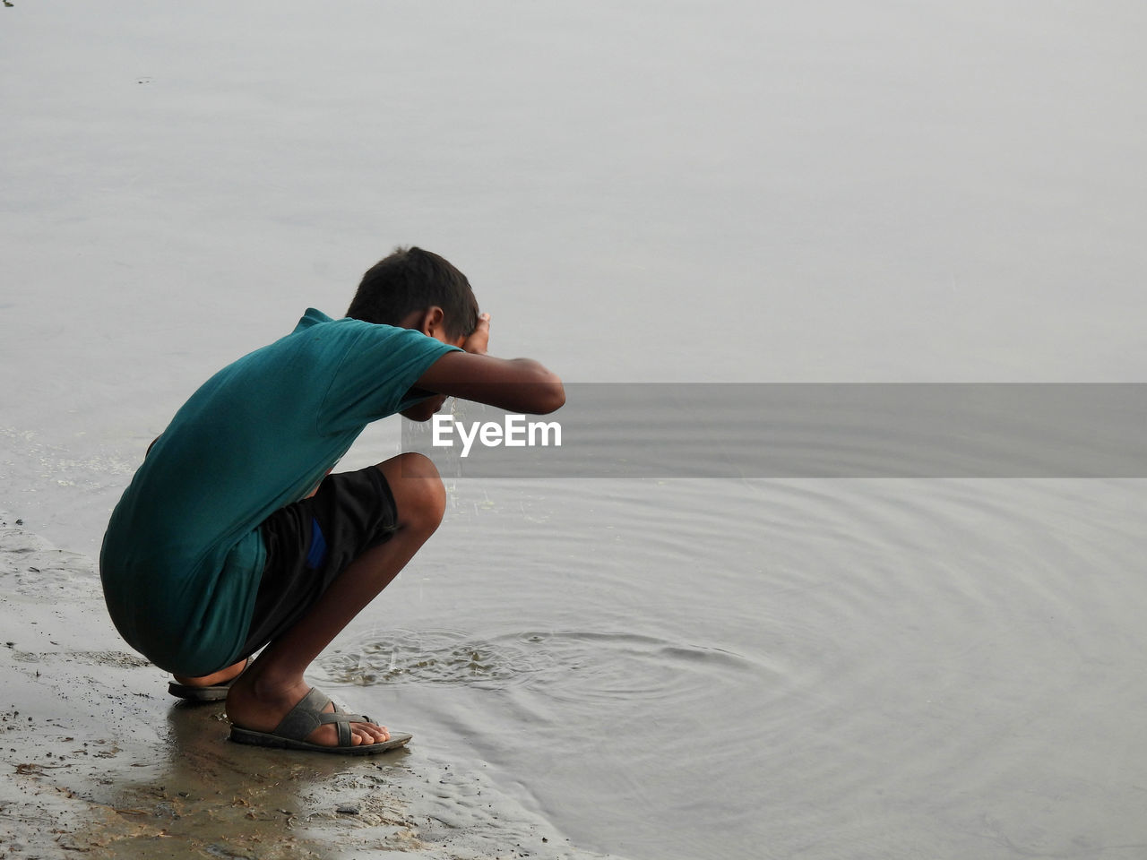 Rear view of boy sitting at beach