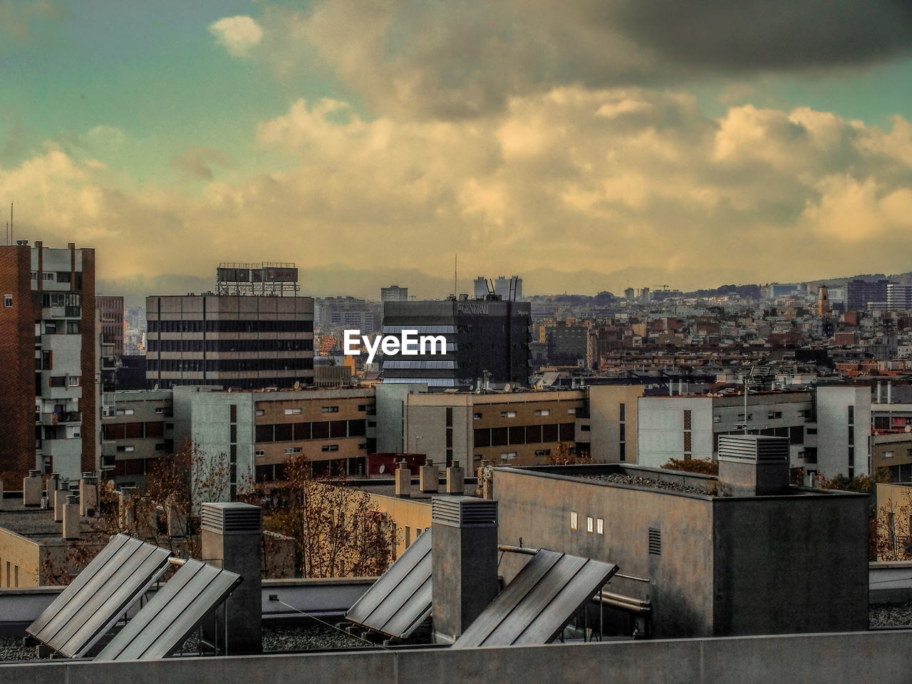 High angle view of barcelona cityscape against cloudy sky