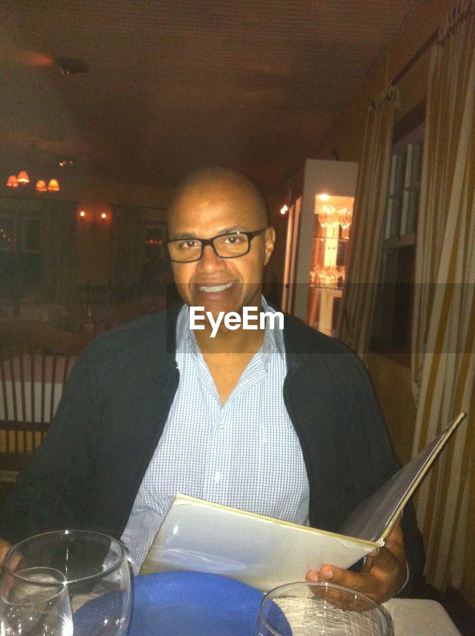 Portrait of man sitting at st-hubert restaurant with menu card