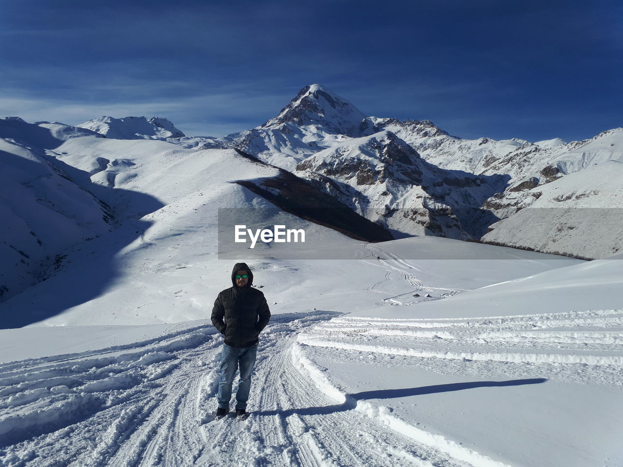 Man standing on snowcapped mountain against sky