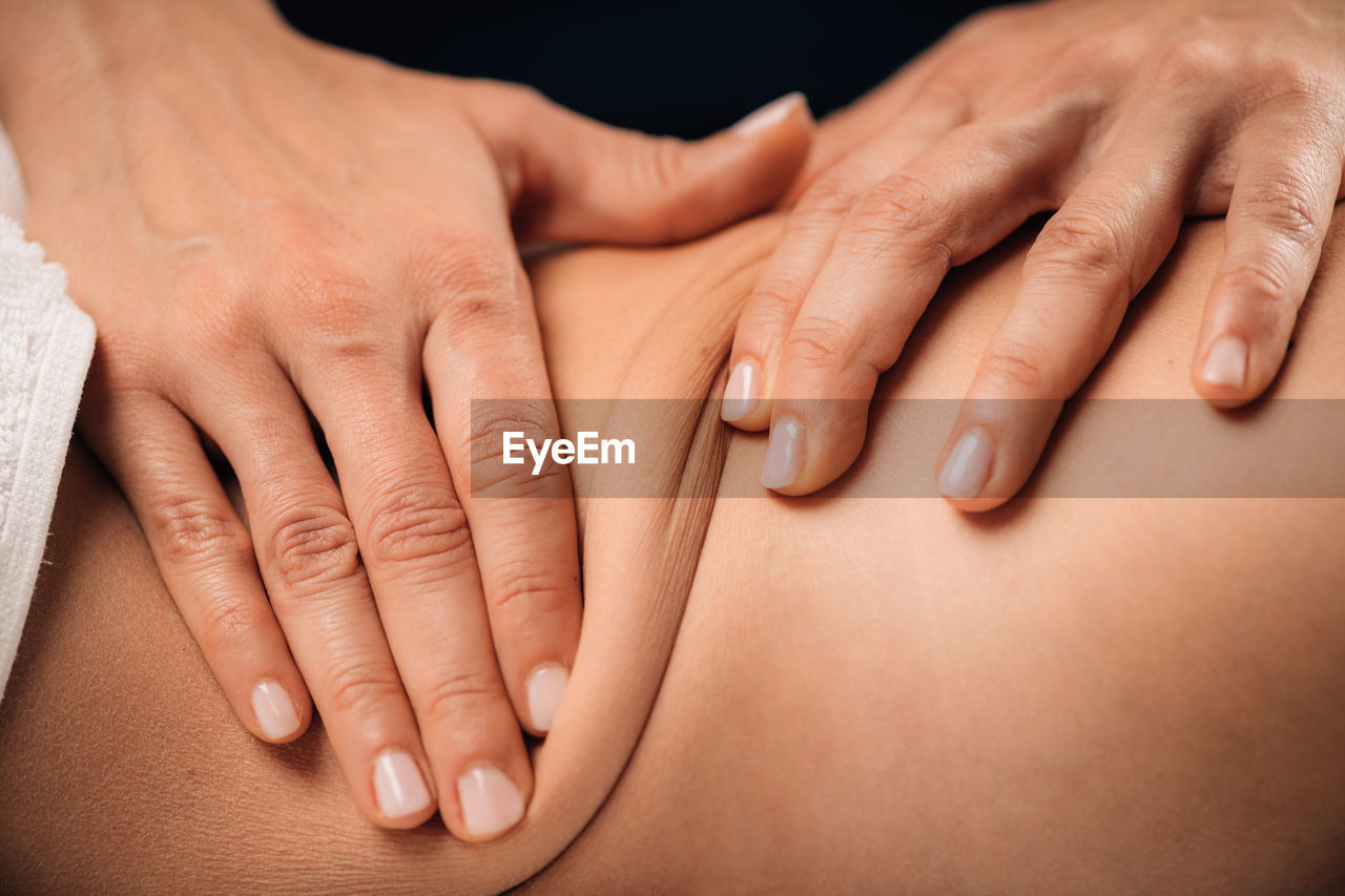 Hands of a female therapist doing a deep tissue back massage