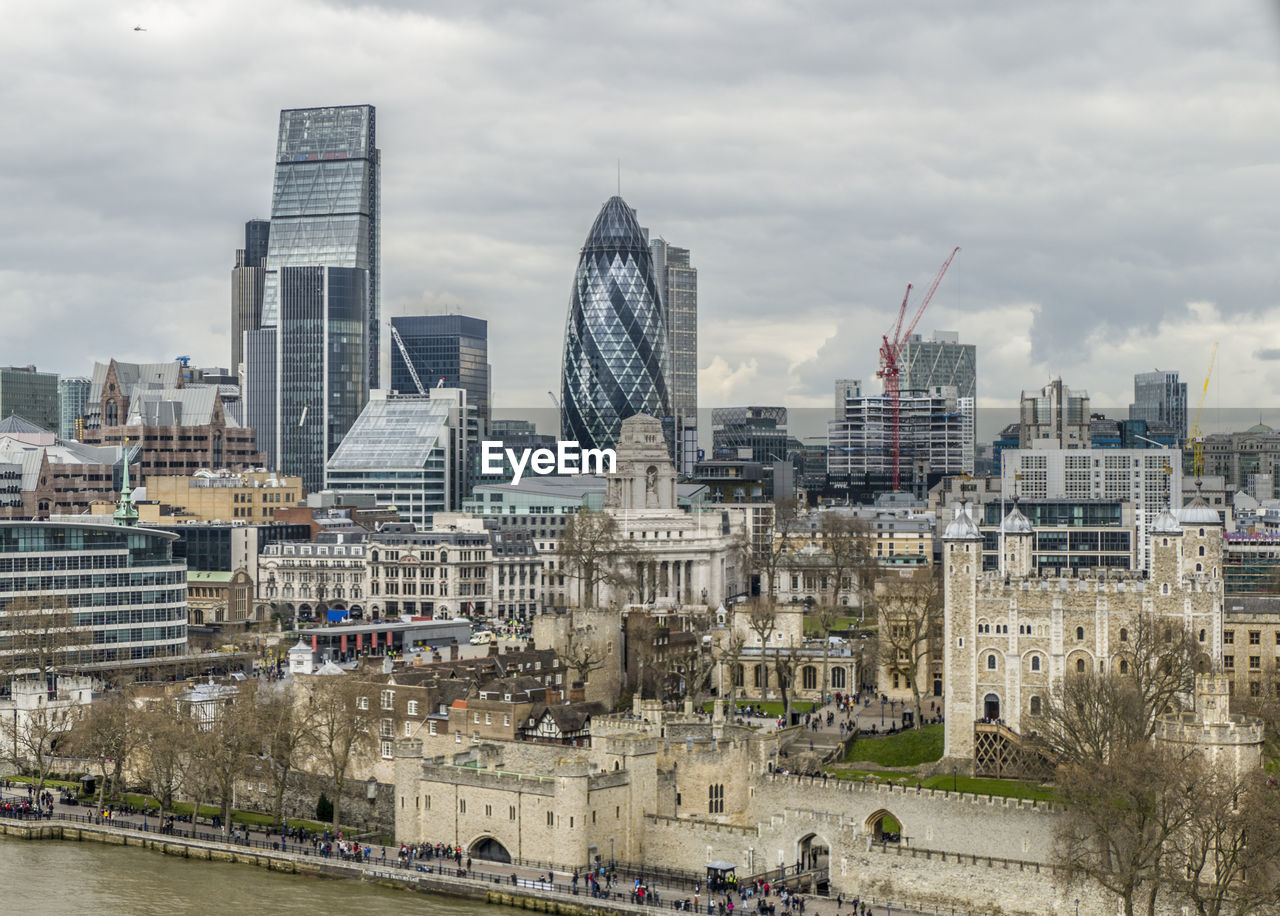 Buildings in city against cloudy sky