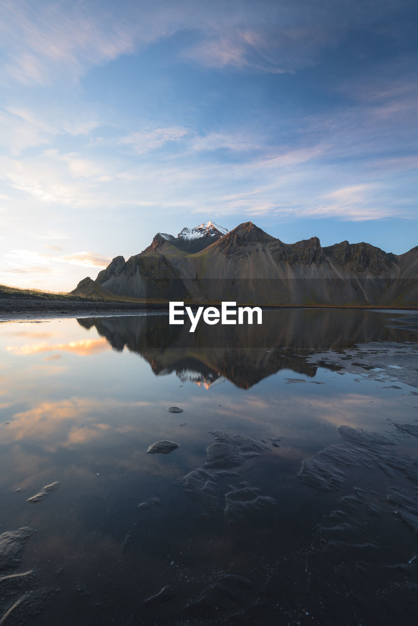 Scenic view of lake by mountains against sky