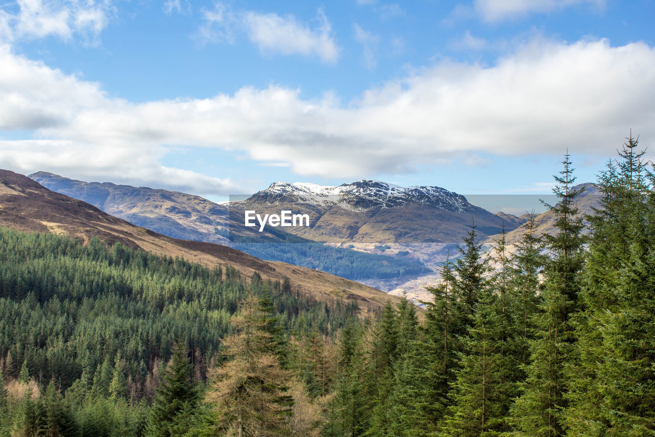 Scenic view of mountains against cloudy sky