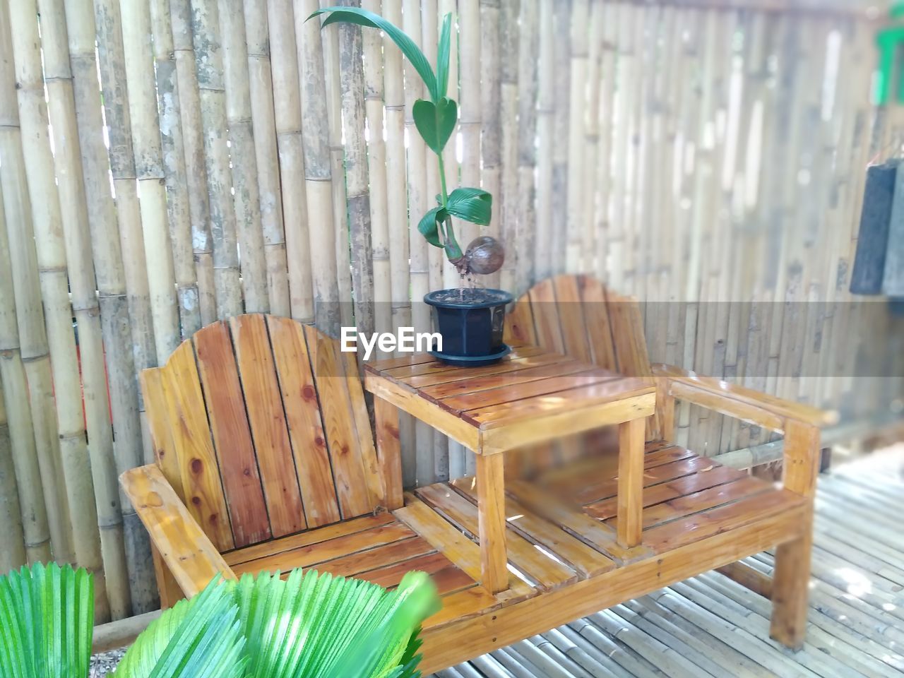 CLOSE-UP OF EMPTY CHAIRS AND TABLE AGAINST WALL