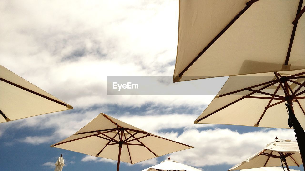 Low angle view of parasols against sky