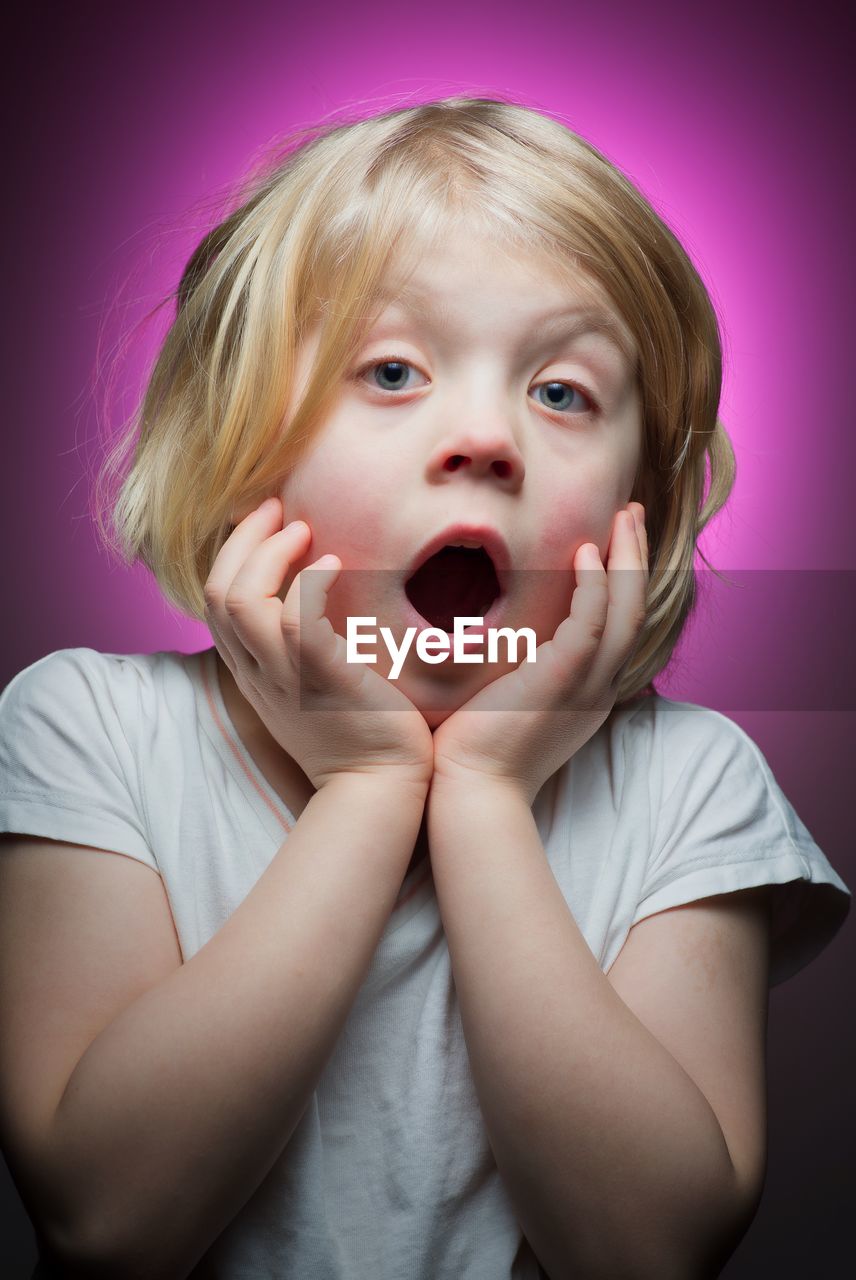 Close-up portrait of girl against pink background