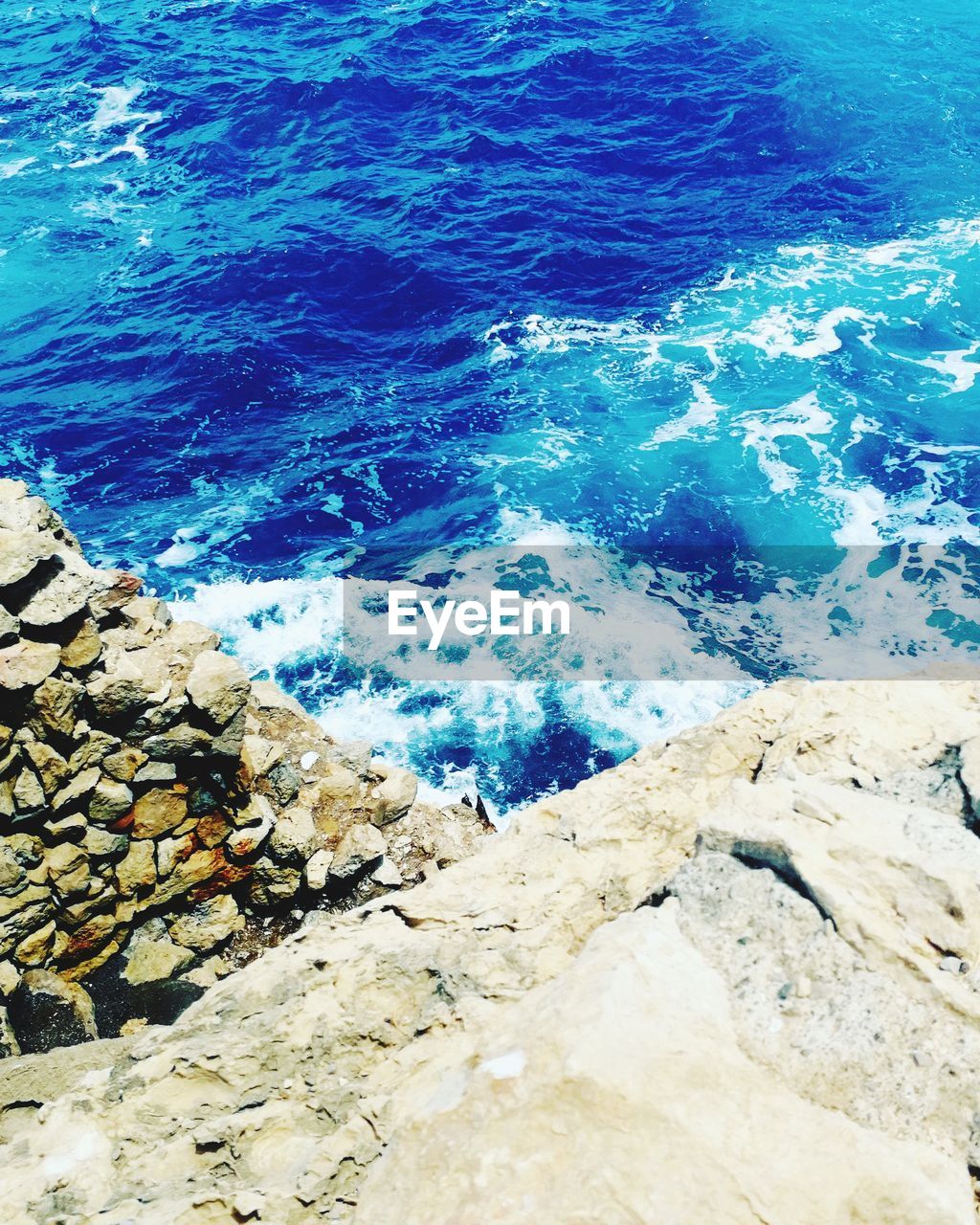 HIGH ANGLE VIEW OF ROCKS AT BEACH