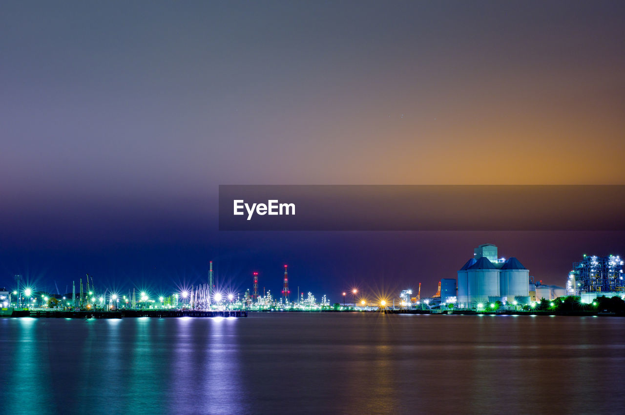 Illuminated buildings at waterfront during night