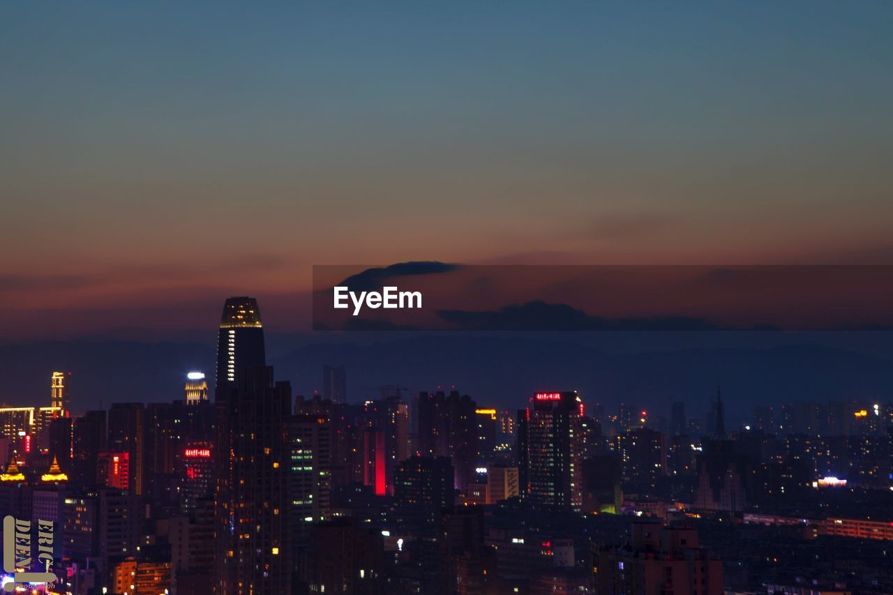 VIEW OF ILLUMINATED CITYSCAPE AT NIGHT