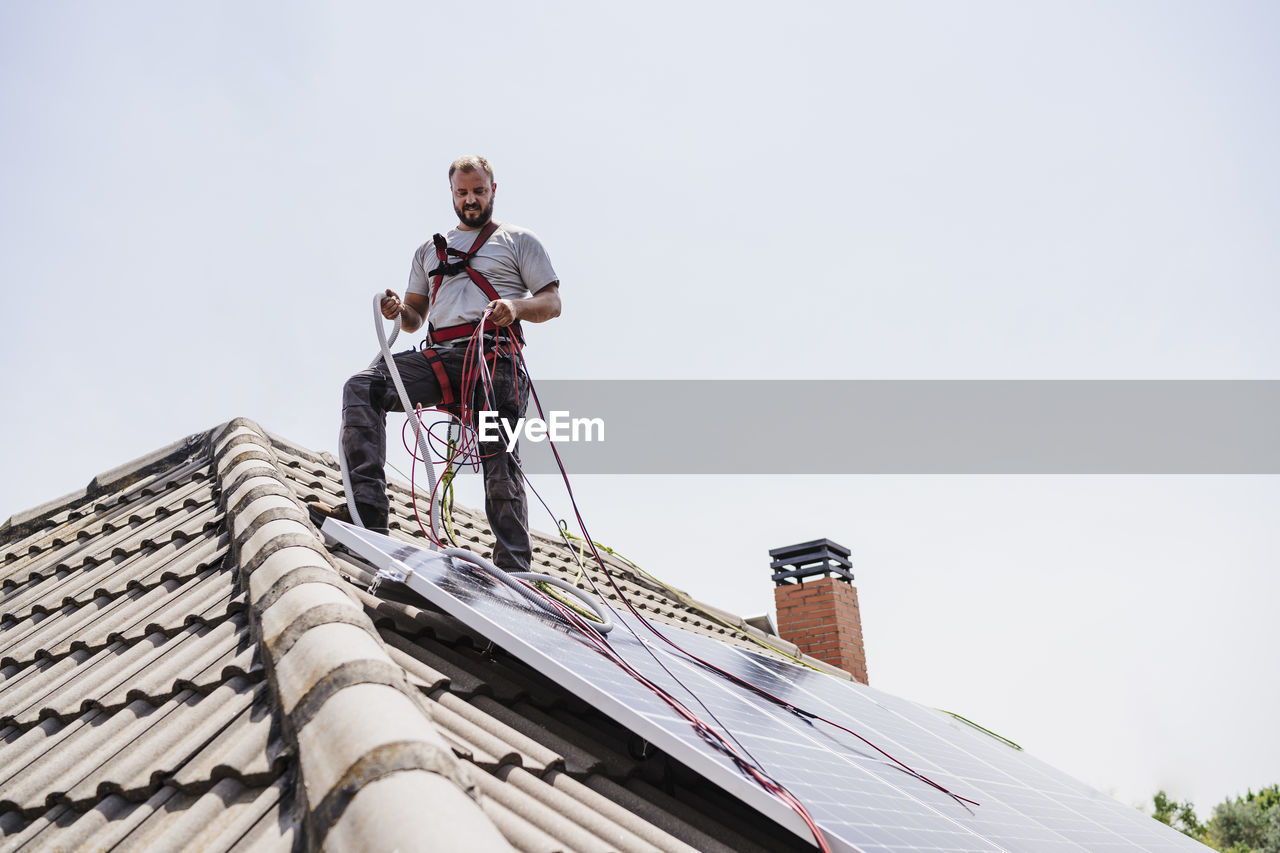Craftsman installing solar panels on rooftop