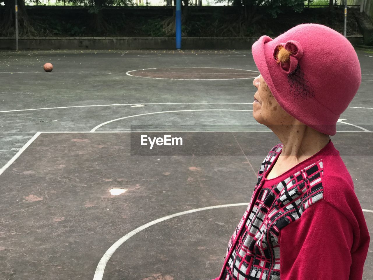 Side view of senior woman standing at basketball court