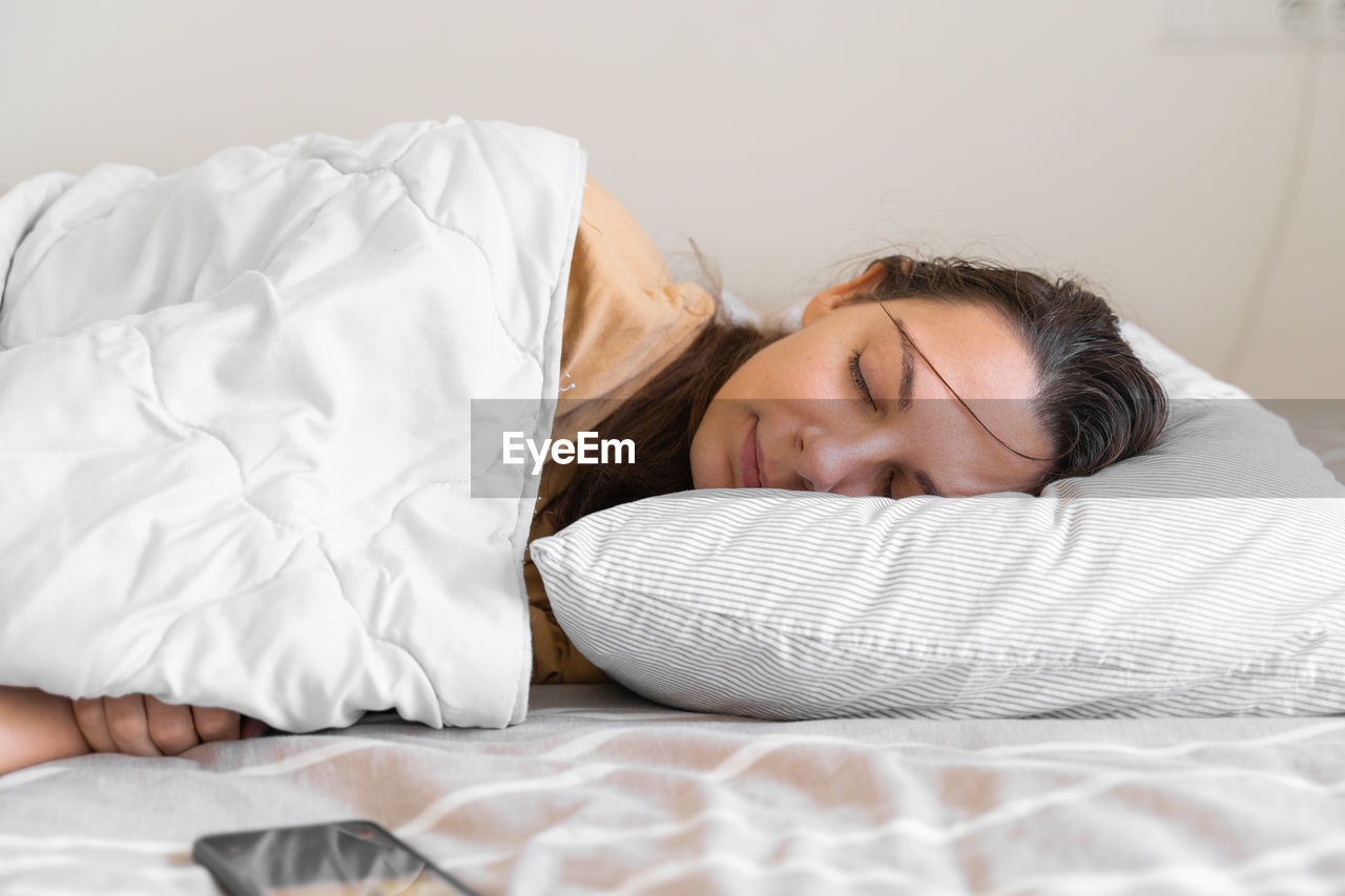 Young woman sleeping on bed at home