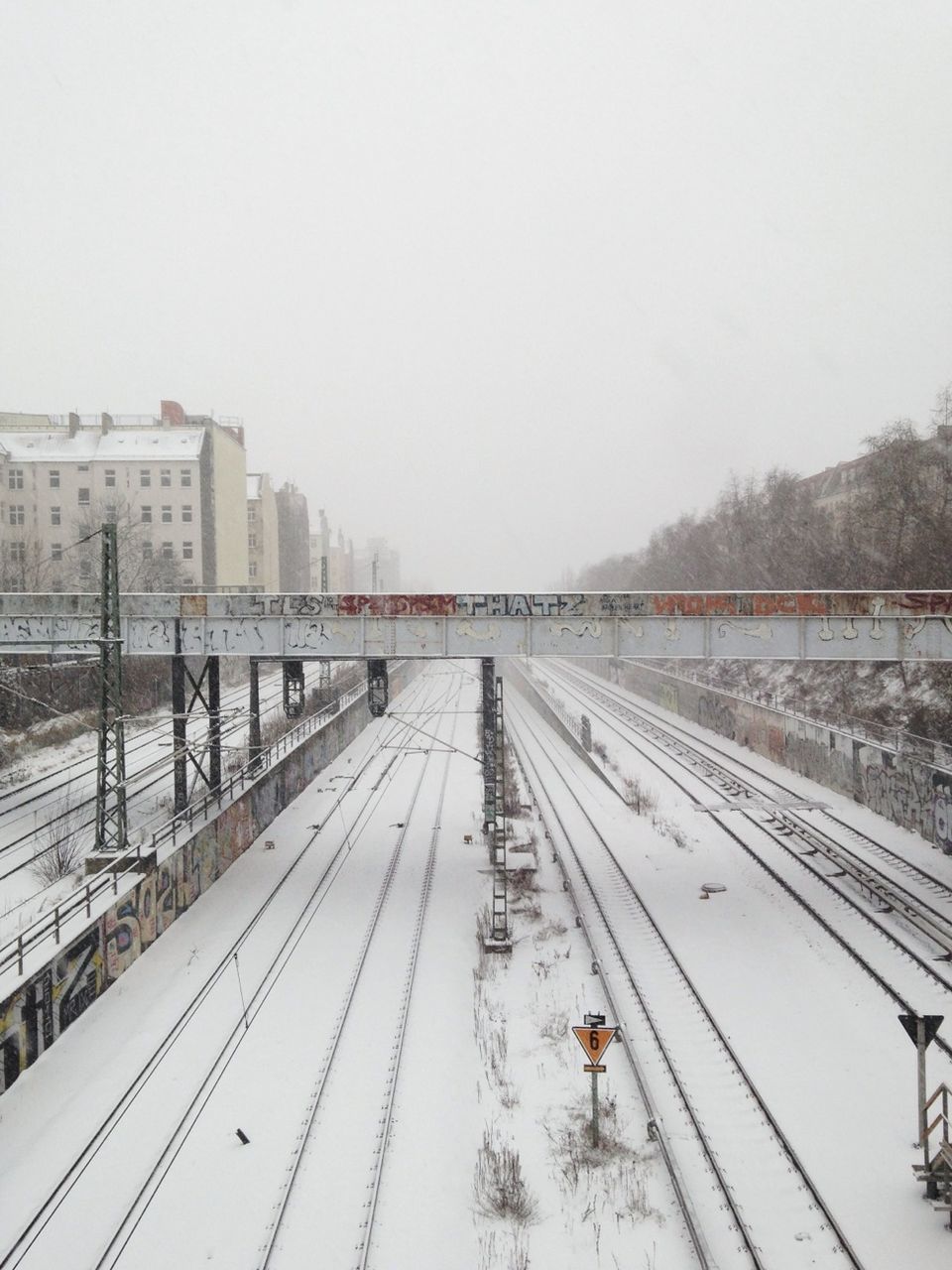 High angle view of snow covered railroad tracks against clear sky