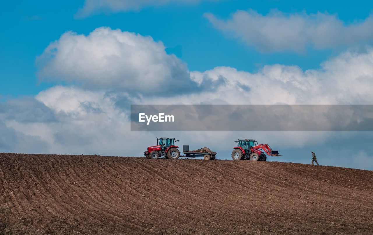 Low angle view of tractor on field against sky