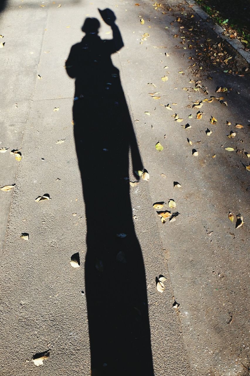SHADOW OF PERSON ON ROAD